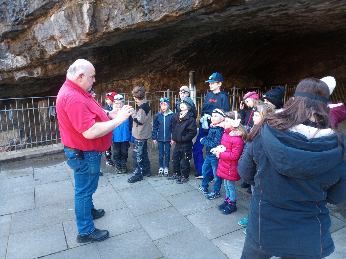 Die Kinderfeuerwehr vor der Teufelshöhle. ein Führer erklärt.