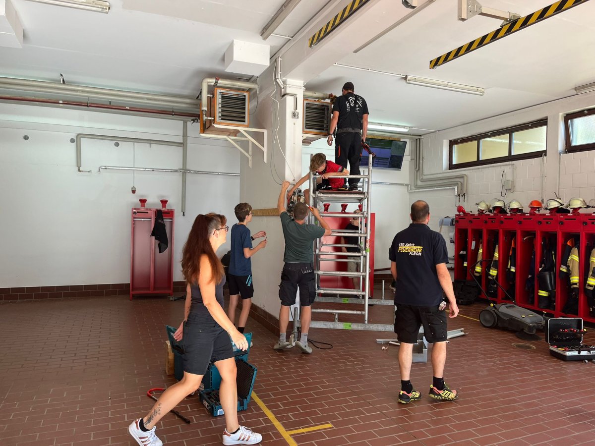 Feuerwehrangehörige bei der Demontage der alten Heizung